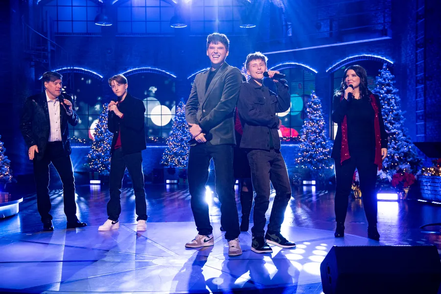The Sharpe Family Singers performing together under blue stage light
